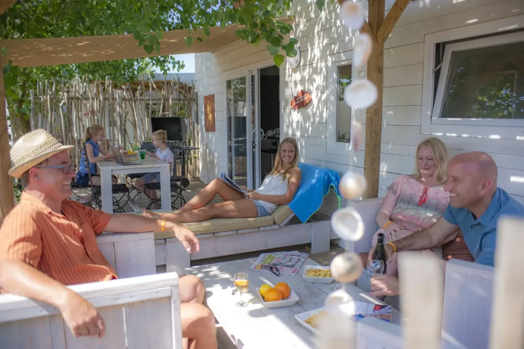Vacanciers sur la terrasse du'un mobil-home premium au camping